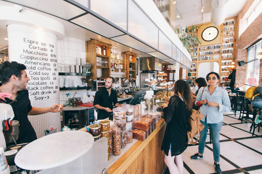 A bright deli with customers at the counter
