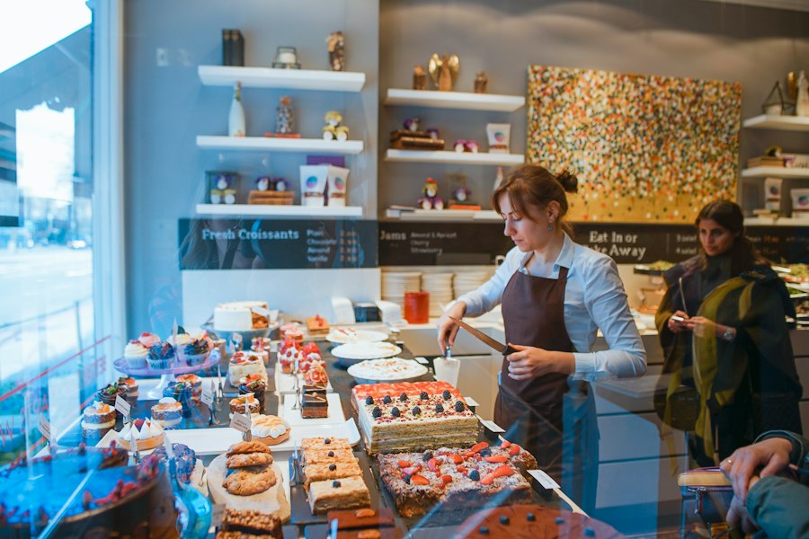 A bakery counter with a customer choosing pastries