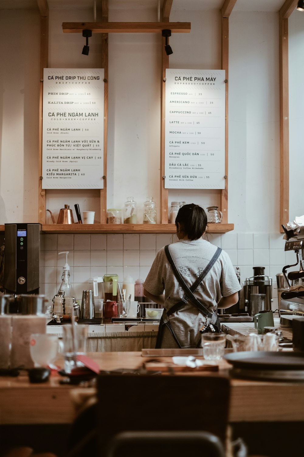 A barista preparing drinks behind the counter
